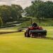 Greenkeeper bruger maskine til at vedligeholde golfbanens fairway
